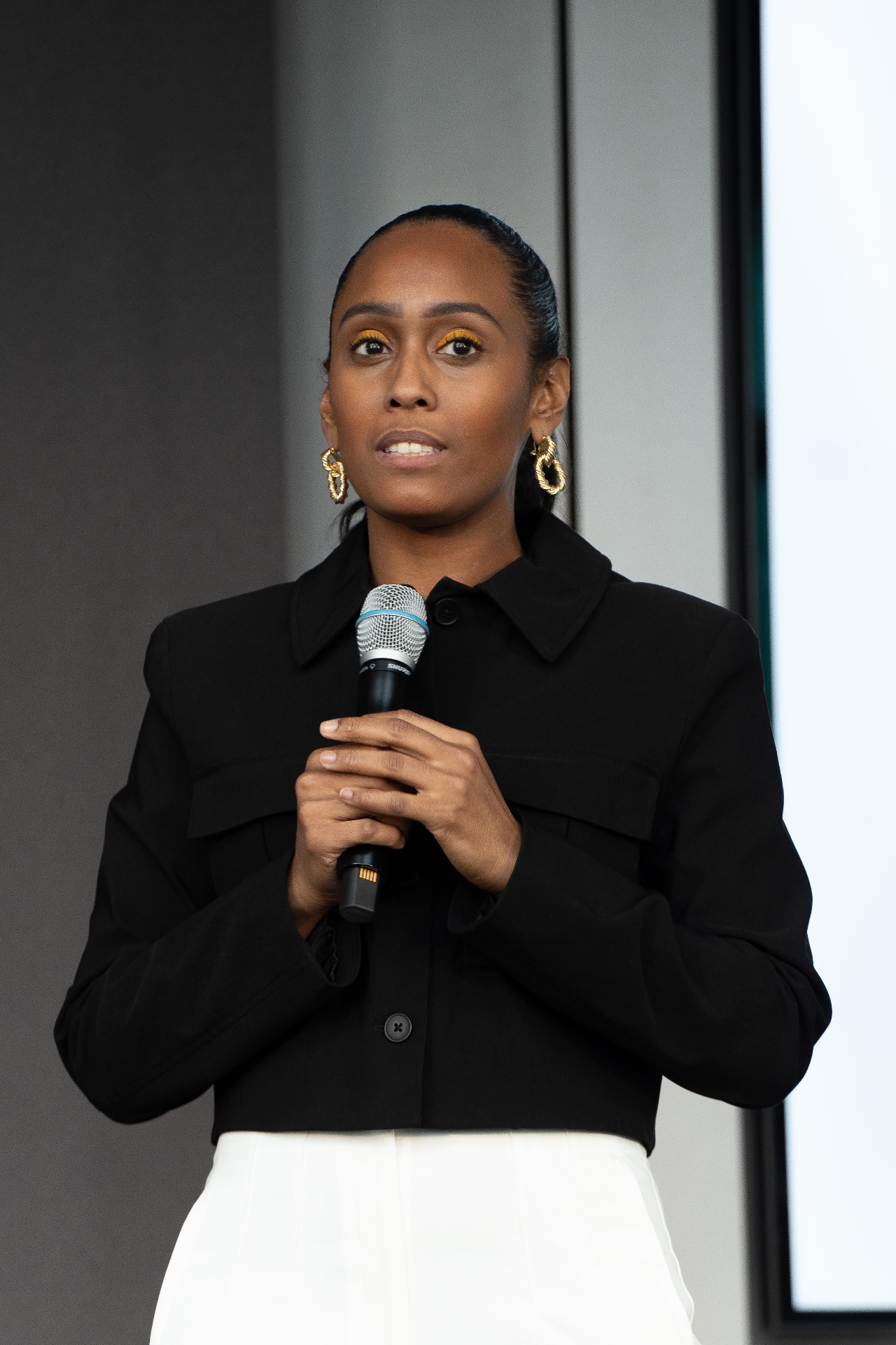 Symone speaking on stage with microphone